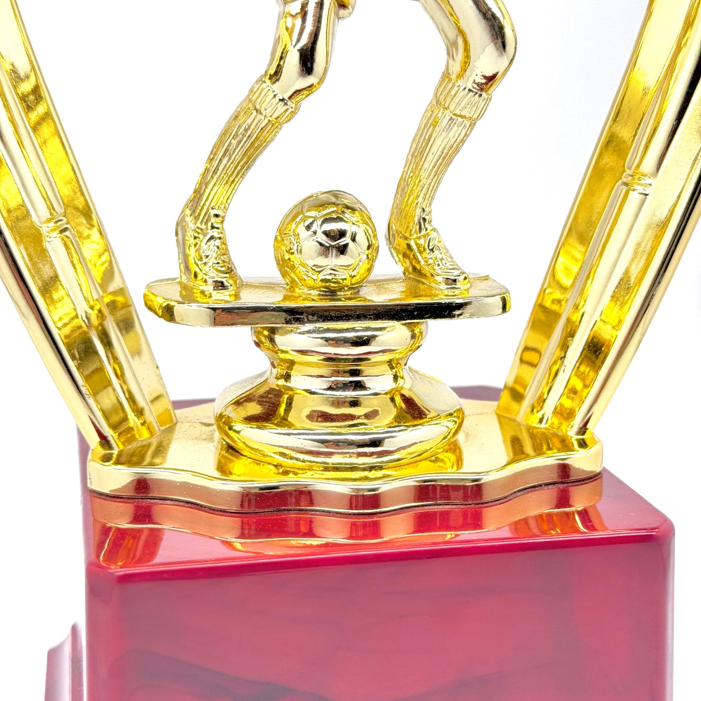 Golden soccer figurine on red marble-style trophy base