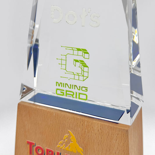 Angled view of a clear crystal award mounted on a wooden base, highlighting the sleek lines and craftsmanship.