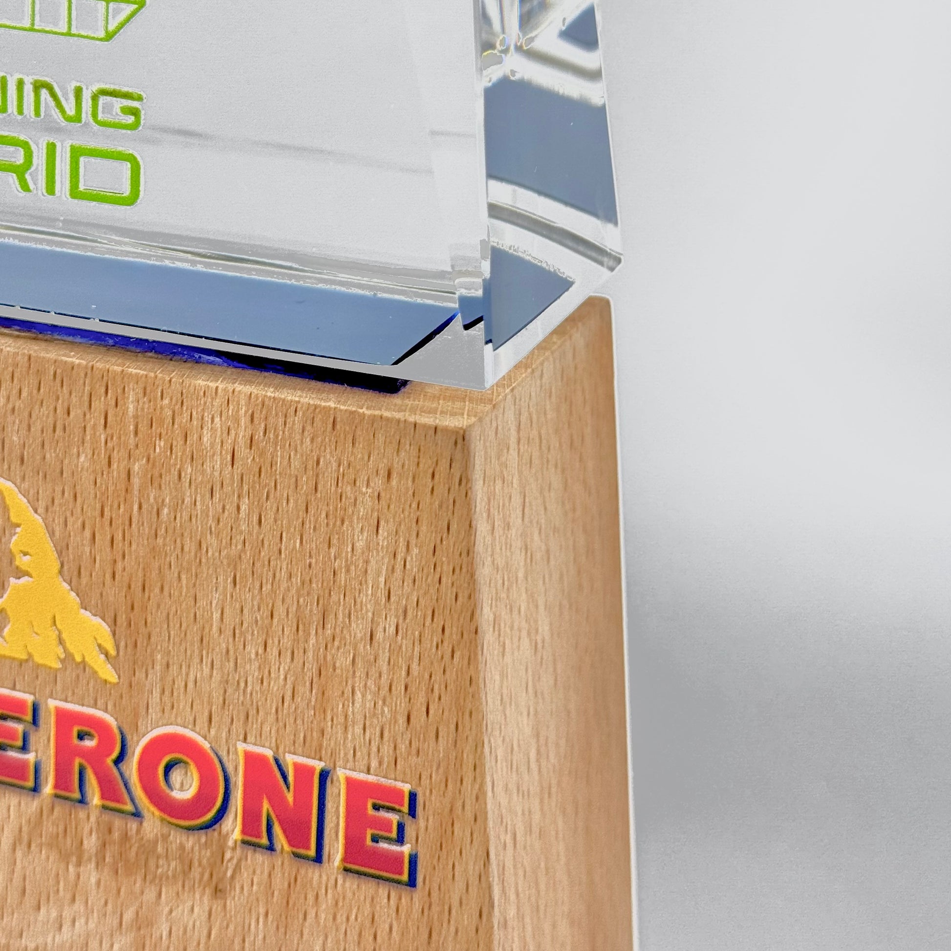 Close-up of a polished wooden award base attached to a crystal top, showcasing refined texture and finish